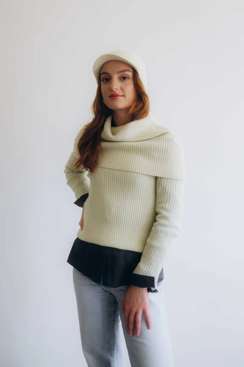 Dámske oblečenie – štvorset TATTJA krémovo-vanilkový na modelke, elegantný pletený komplet s čiapkou a nákrčníkom v jemnom tóne.