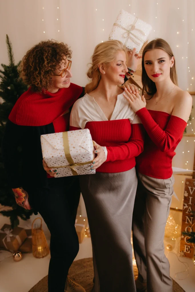 Pletené doplnky TATTJA v červenej farbe na troch modelkách, ktoré ukazujú možnosti kombinovania jedného setu v elegantnom dámskom outfite.