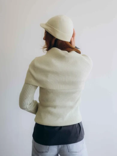 Dámske oblečenie – štvorset TATTJA krémovo-vanilkový na modelke, elegantný pletený komplet s čiapkou a nákrčníkom v jemnom tóne.