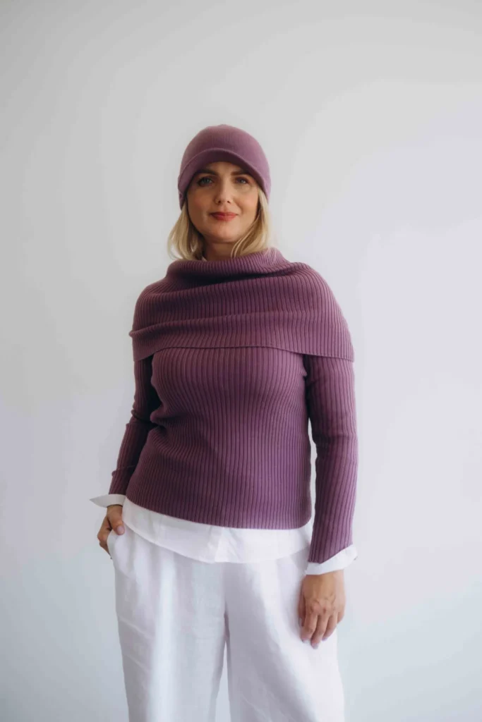 Dámske oblečenie štvorset TATTJA tmavofialový na modelke, elegantný pletený komplet s čiapkou a nákrčníkom v noblesnej farbe.